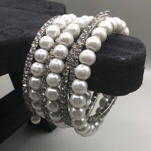 Faux pearls and rhinestones coil statement bracelet wide.
